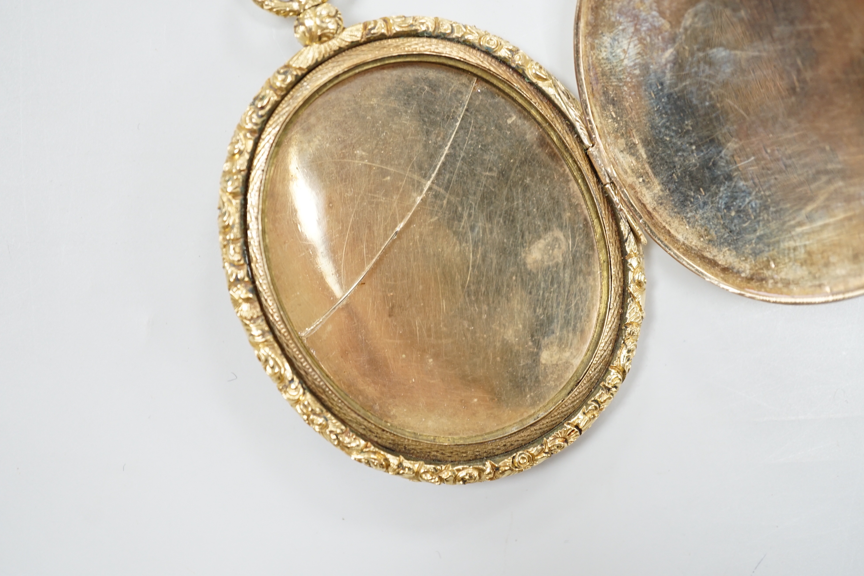 A Victorian engine turned yellow metal overlaid oval pendant locket, housing a miniature on ivory depicting a lady, overall 7.75cm, gross 41 grams CITIES Submission reference, TVTSSFBX